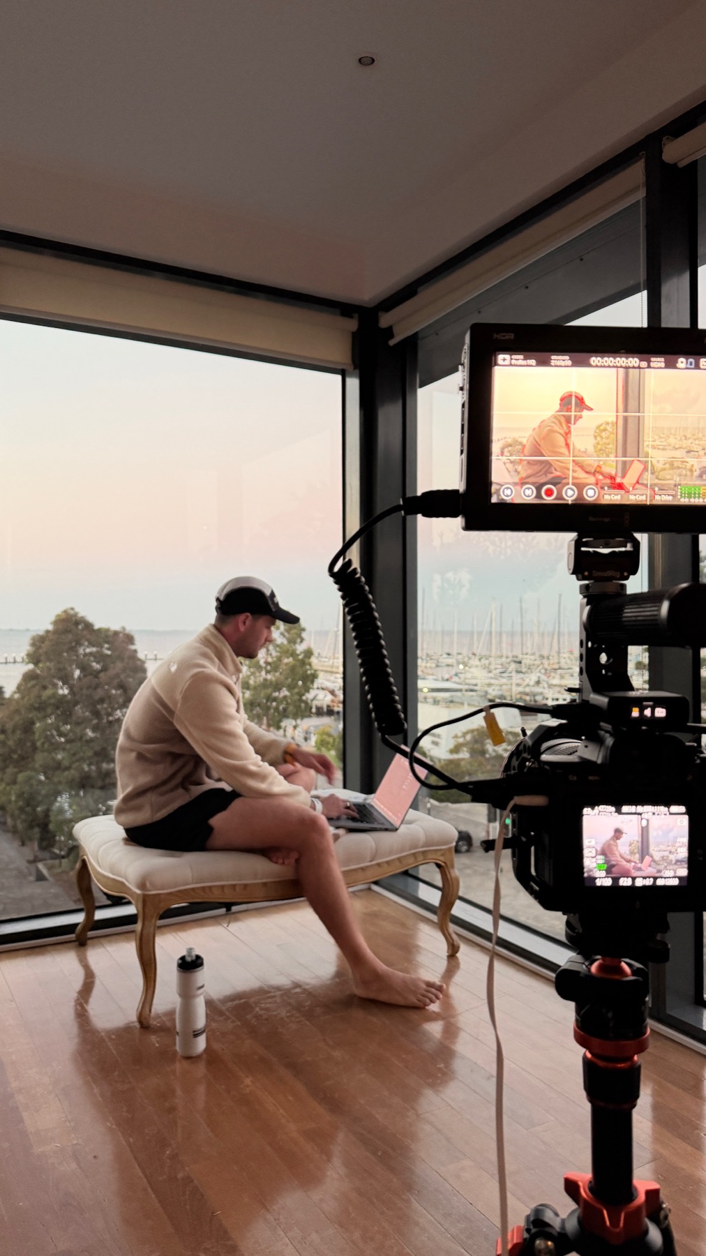 Lachlan Holmes filming a piece to camera overlooking the marina